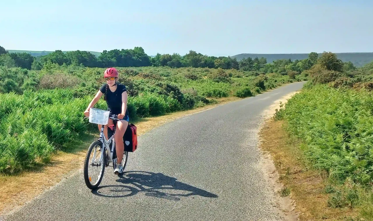 Ever Prel cycling through green English countryside on a sunny summer day