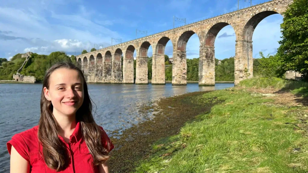 Ever Prel standing by the historic Berwick Bridge over the River Tweed on a sunny day in Berwick-upon-Tweed.