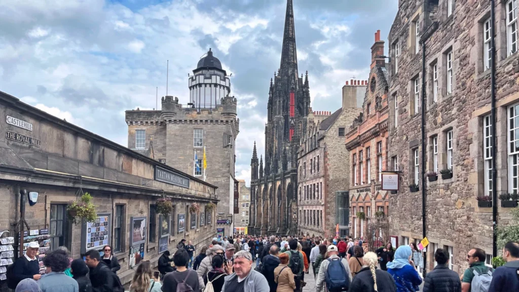 Castle Hill and Royal Mile with historic buildings and tourists on a cloudy day in Edinburgh