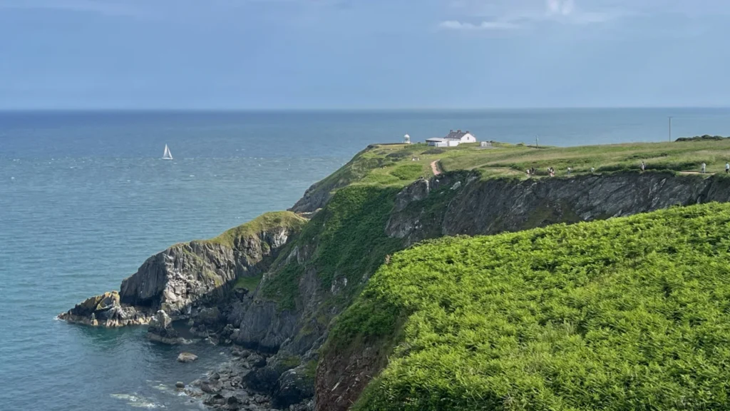 Cliffs and headland of Howth Head in Ireland seen from the Howth Cliff Walk trail on a summer afternoon
