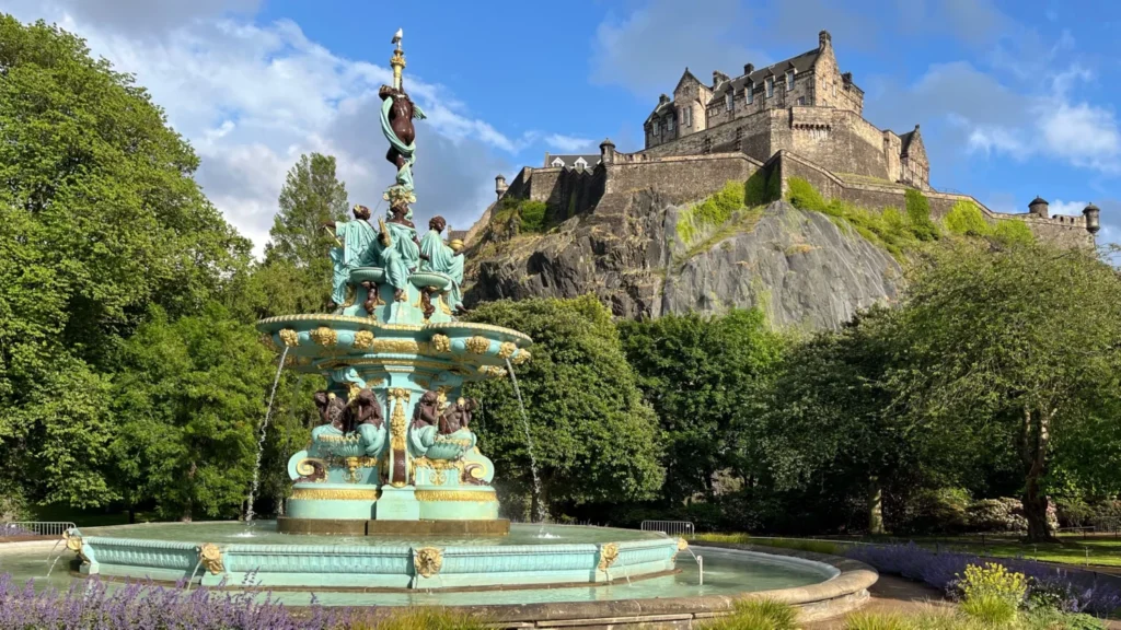 Ross Fountain in Princes Street Gardens with Edinburgh Castle on Castle Rock in the background on a sunny day