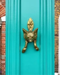 Collage featuring two of Dublin's colourful doors, one red and one yellow, with a close-up image of a brass doorknob on a blue-painted door in the centre.