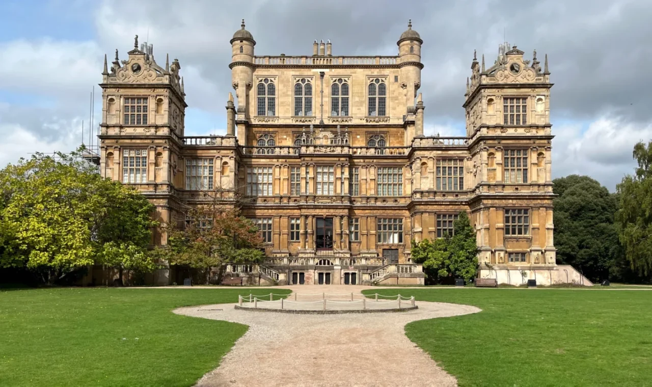 Wollaton Hall facade with trees and park, sunny day, Nottingham