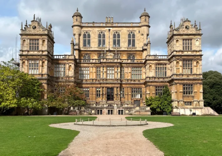 Wollaton Hall facade with trees and park, sunny day, Nottingham