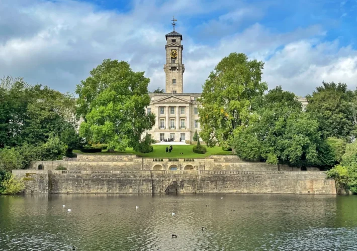 Highfields Park Nottingham England with boating lake and University of Nottingham Trent building in the background