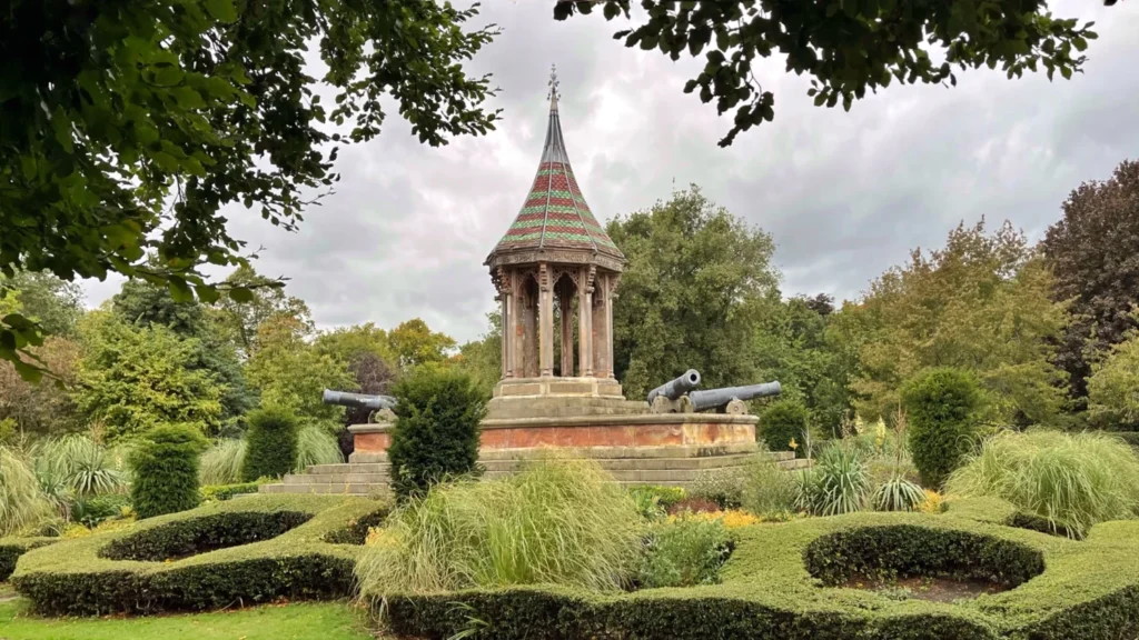 The Arboretum, one of the best parks in Nottingham England, with Chinese Bell Tower surrounded by flowerbeds and trimmed bushes