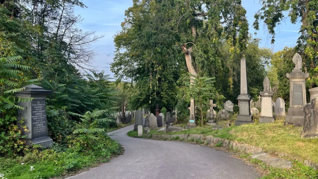 Nottingham General Cemetery England with lush green trees, bushes, and old graves along a path