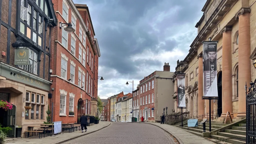 Historic street scene during a weekend in Nottingham with traditional brick buildings and the National Justice Museum on a cloudy day