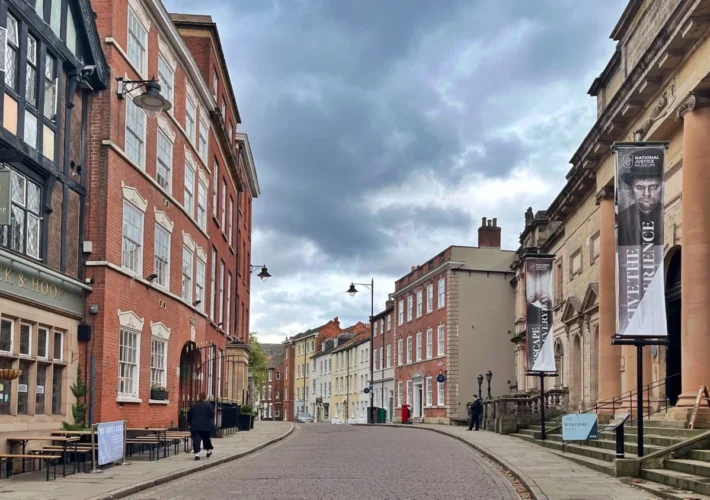 Historic street scene during a weekend in Nottingham with traditional brick buildings and the National Justice Museum on a cloudy day