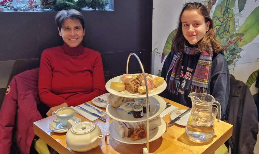 My mum and I enjoying afternoon tea at Odd Fellows in Chester, England, with a traditional platter of scones and treats on the table.