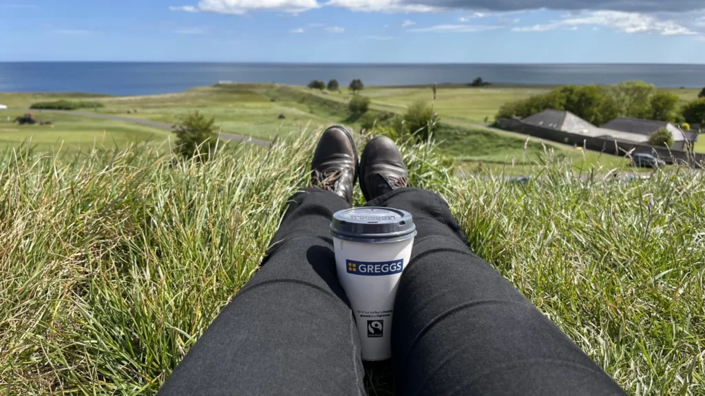 View from the Brass Bastion in Berwick-upon-Tweed over the Elizabethan walls towards the sea, with a Greggs coffee cup in the foreground