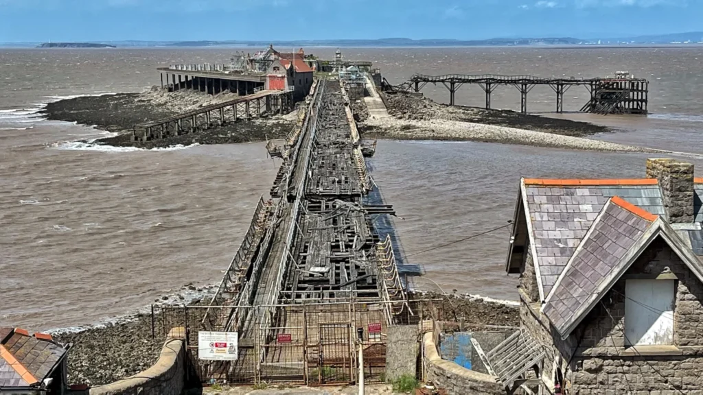 Derelict wooden Birnbeck Pier stretching over mudflats in Weston-super-Mare
