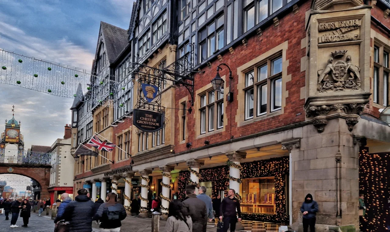 The Chester Grosvenor hotel facade with the Eastgate Clock visible down the street, decorated with Christmas lights