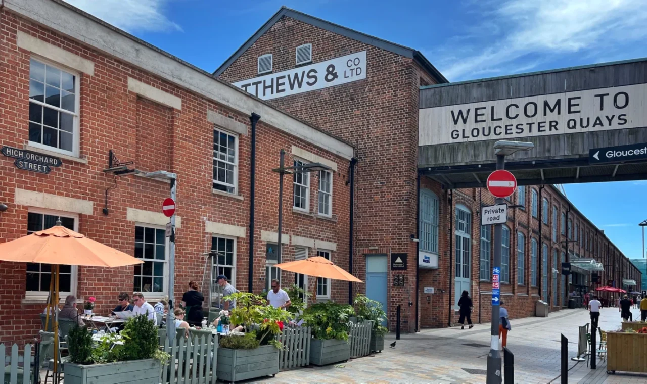 Victorian warehouses at Gloucester Quays with the entrance sign to the docks