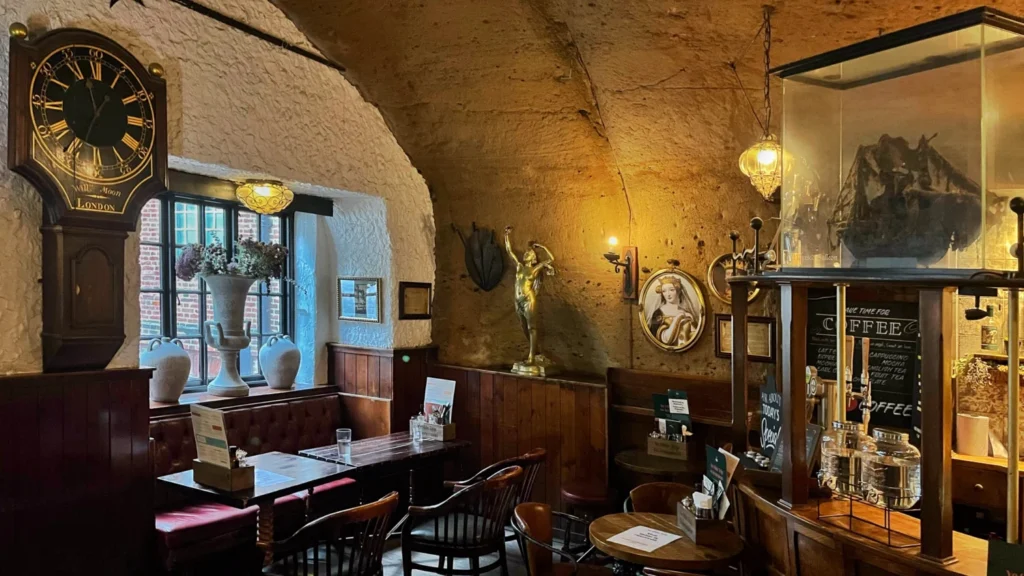 Historic interior of Ye Olde Trip to Jerusalem pub with antique clock and cave-carved walls