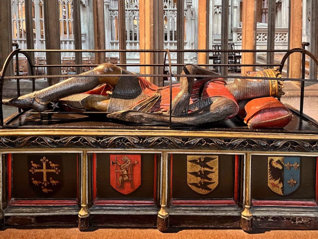 The painted wooden effigy of Robert Curthose, cross-legged in mail on a chest of heraldic shields