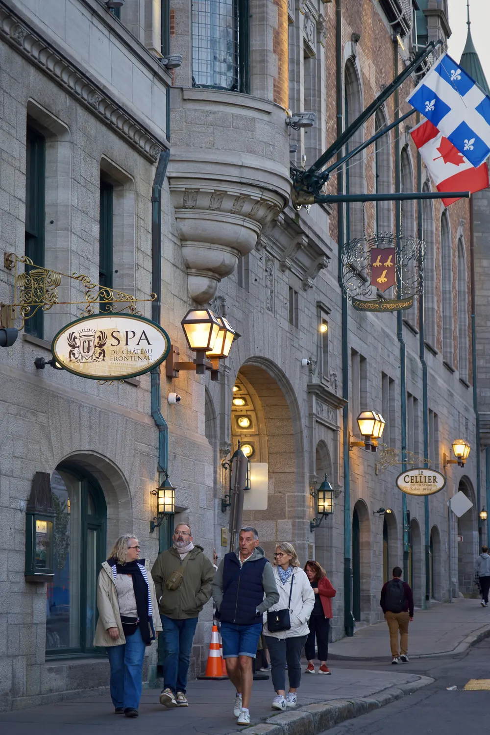 Château Frontenac spa sign and Québec flag on a stone street in Old Québec