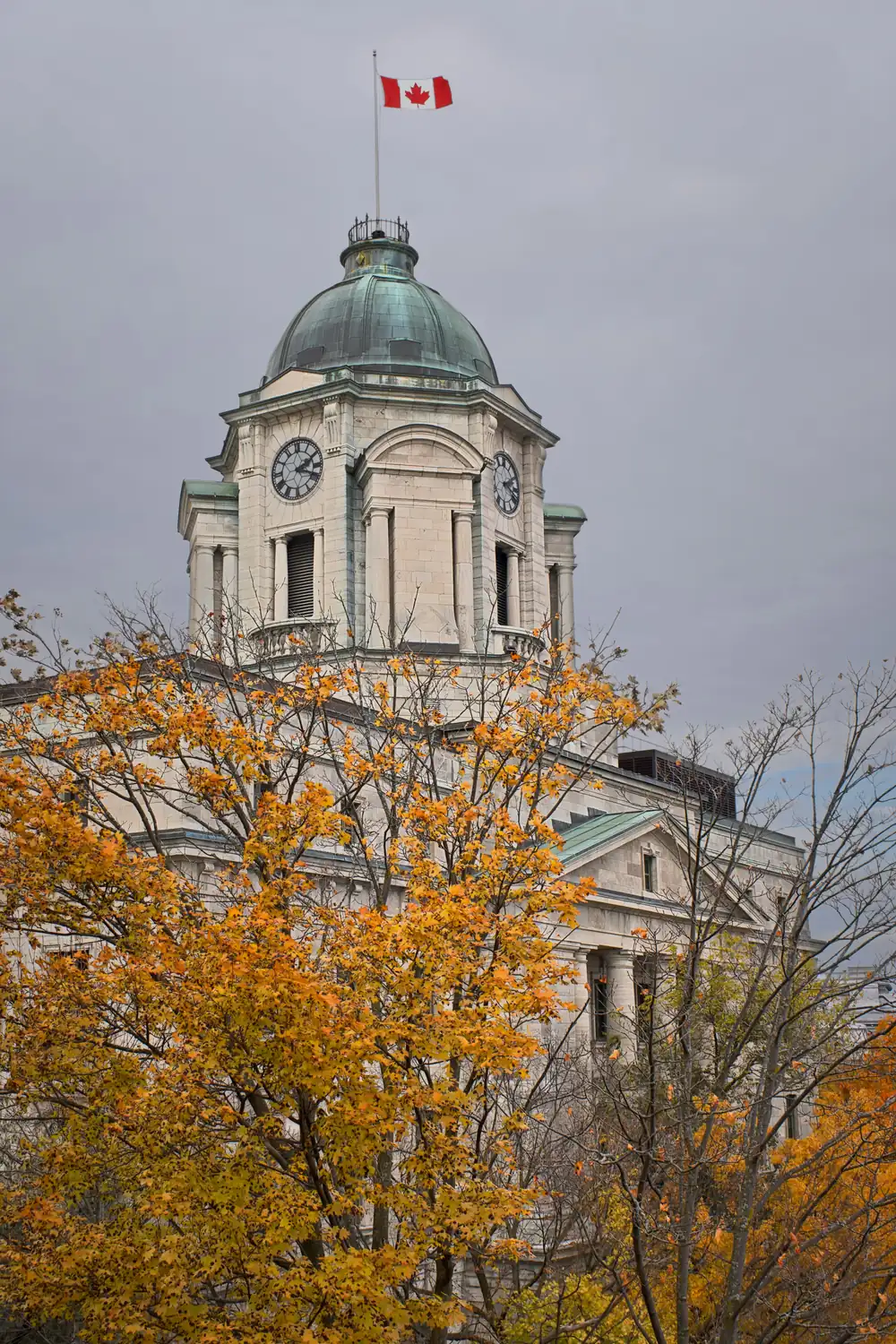 Copper dome and clock tower of the old post office behind an orange tree in Québec City